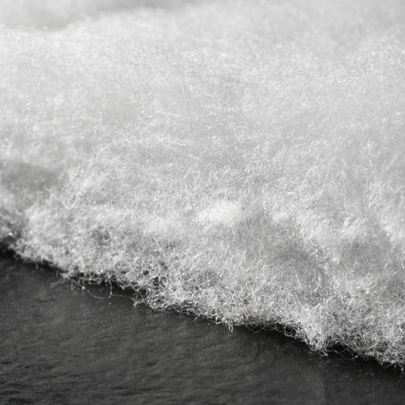 a close up of a piece of white fabric on a black surface .