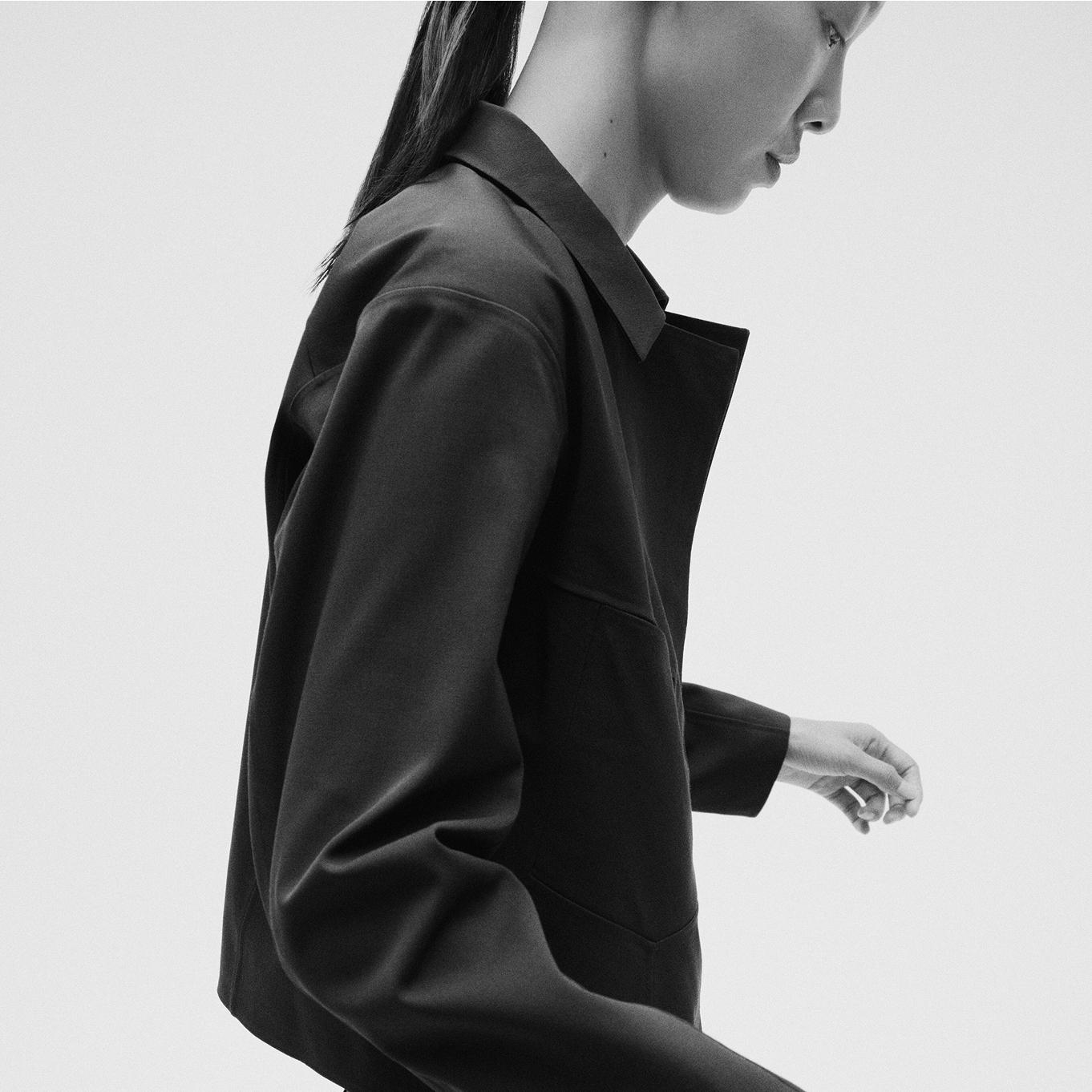 a black and white photo of a woman wearing a black jacket.