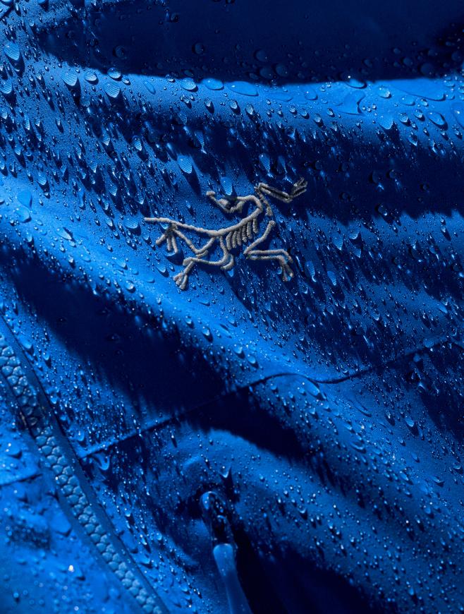 Blue Arc'teryx jacket covered in water droplets.