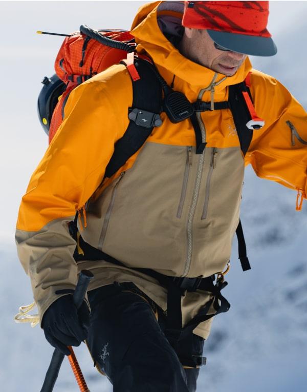 a man wearing a yellow jacket with the word arcteryx on it
