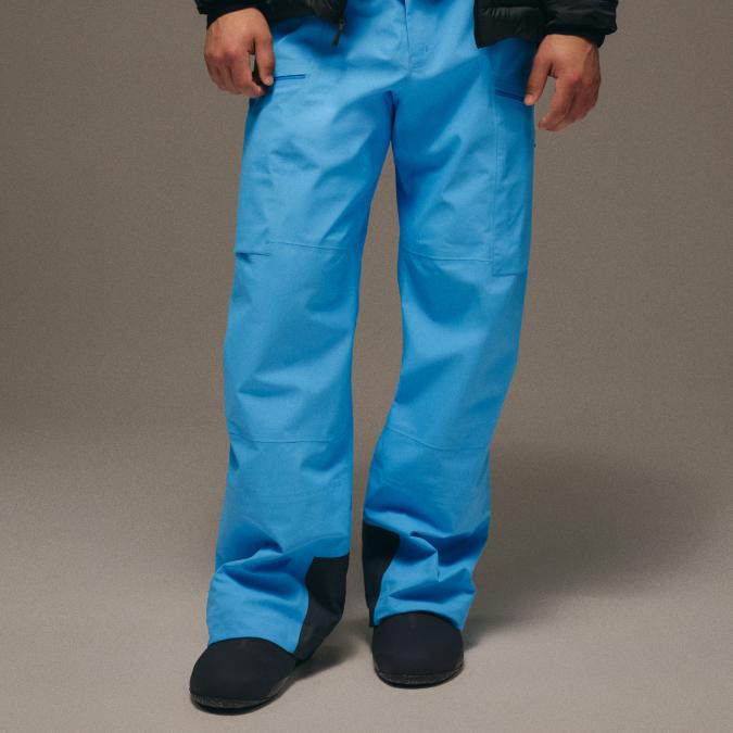 Person wearing bright blue snow pants and dark shoes.