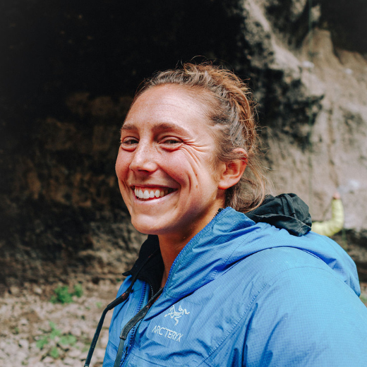 a woman is smiling while climbing a rock wall