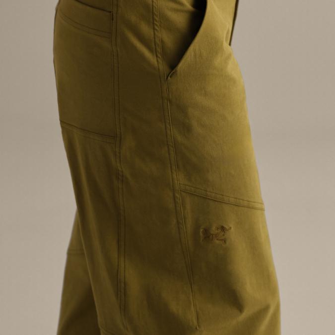 Close-up of olive green pants with visible seams and an Arc'teryx logo.
