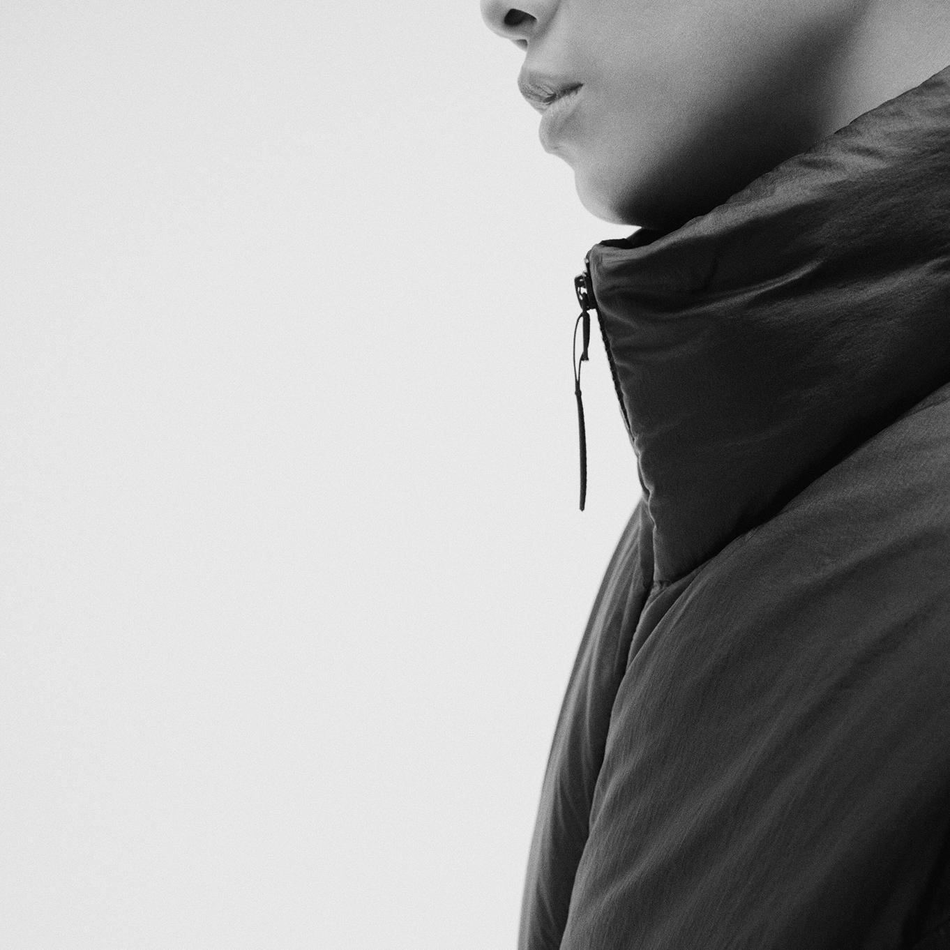 a black and white photo of a woman wearing a black jacket.