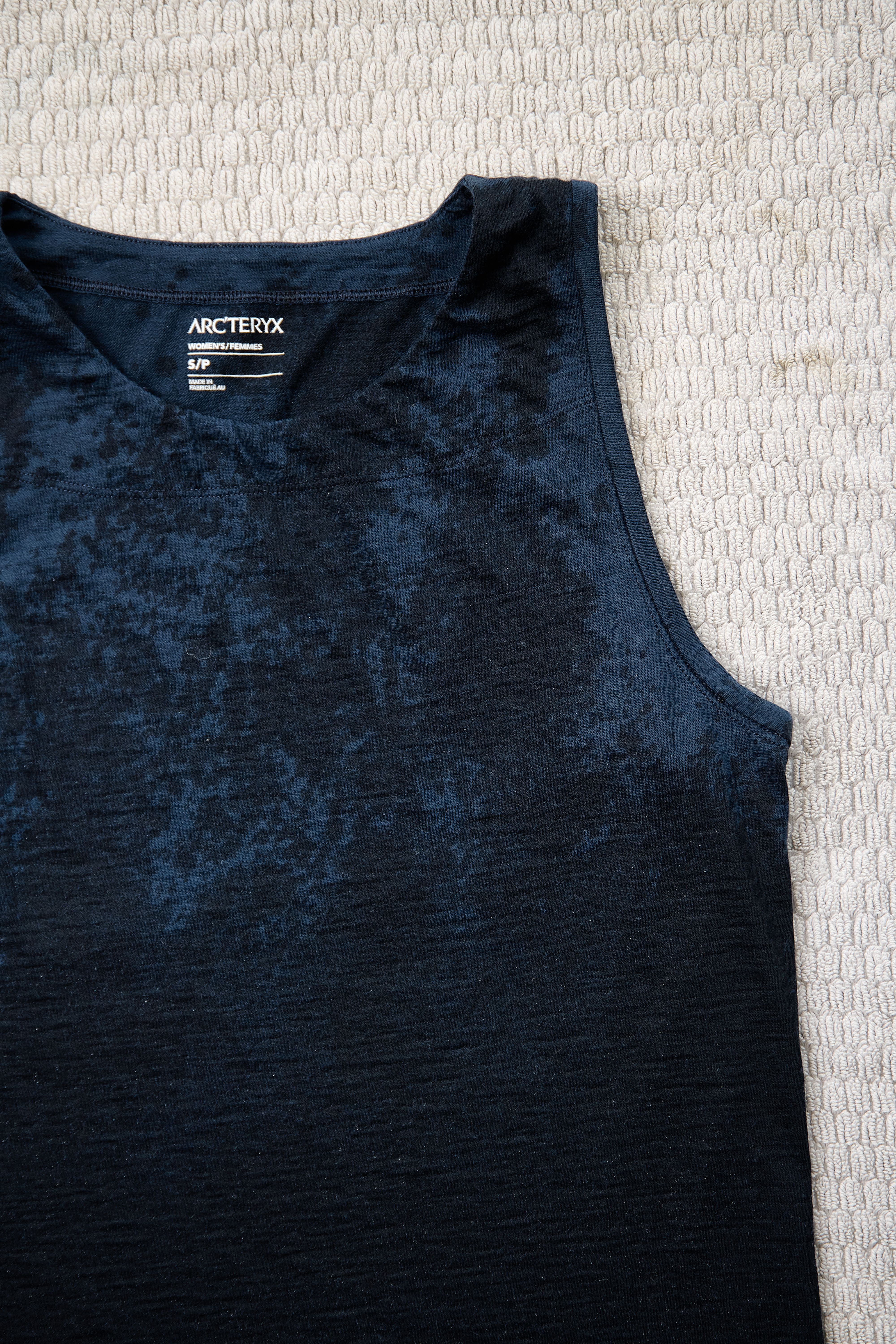 Arc'teryx dark blue mottled tank top on a light textured surface.