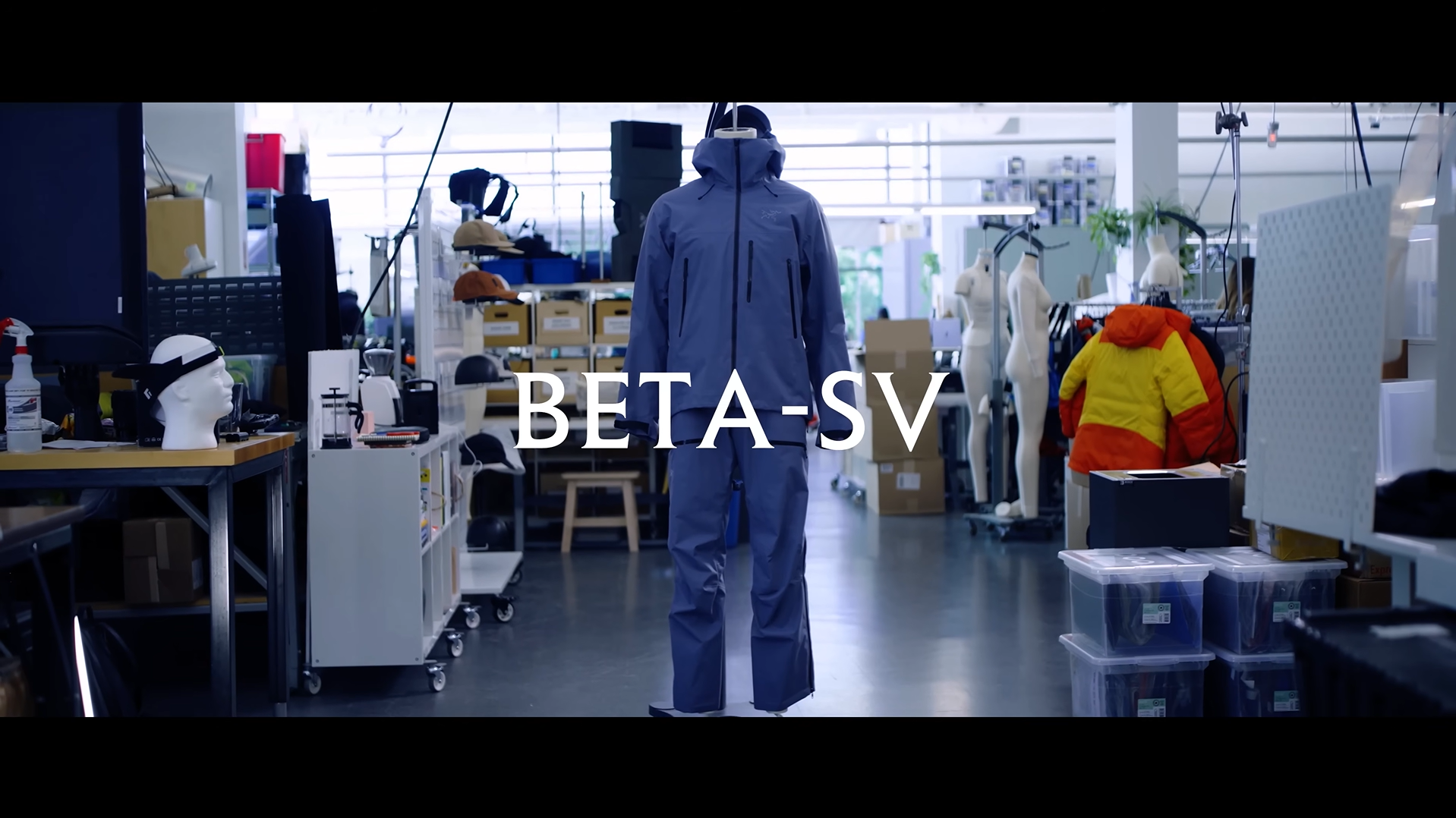 A blue outdoor suit on a mannequin in a workshop, with the text BETA-SV overlaid.