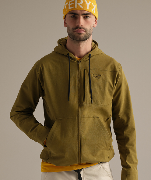 A man wearing a yellow Arc'teryx beanie and a green full-zip hoodie.