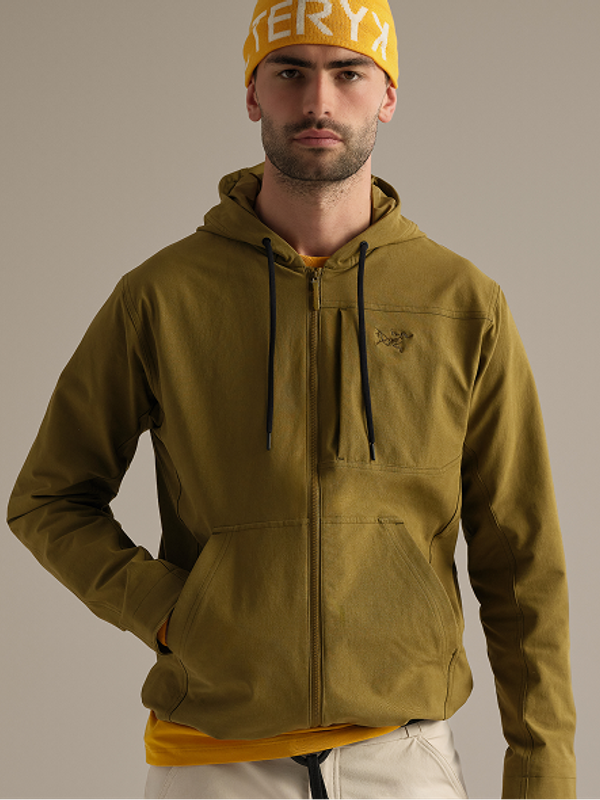 A man wearing a yellow Arc'teryx beanie and a green full-zip hoodie.