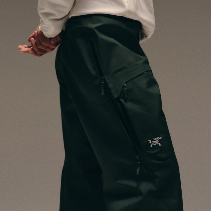 Dark green Arc'teryx pants with multiple zippers.