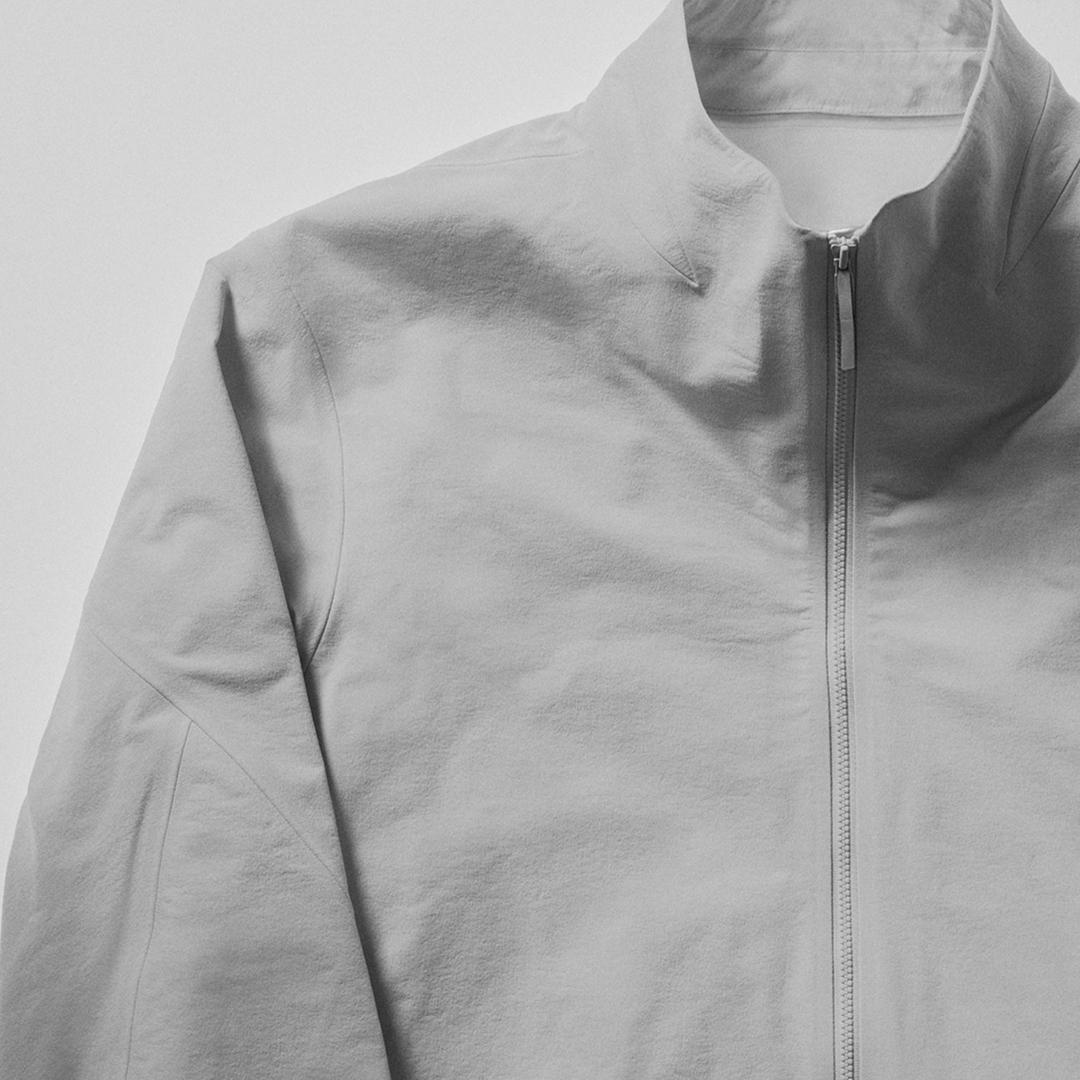 Light grey zipped jacket with a high collar.