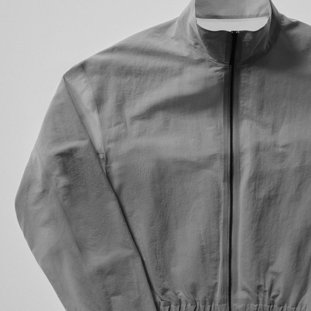 Grey lightweight zippered jacket with a stand collar.