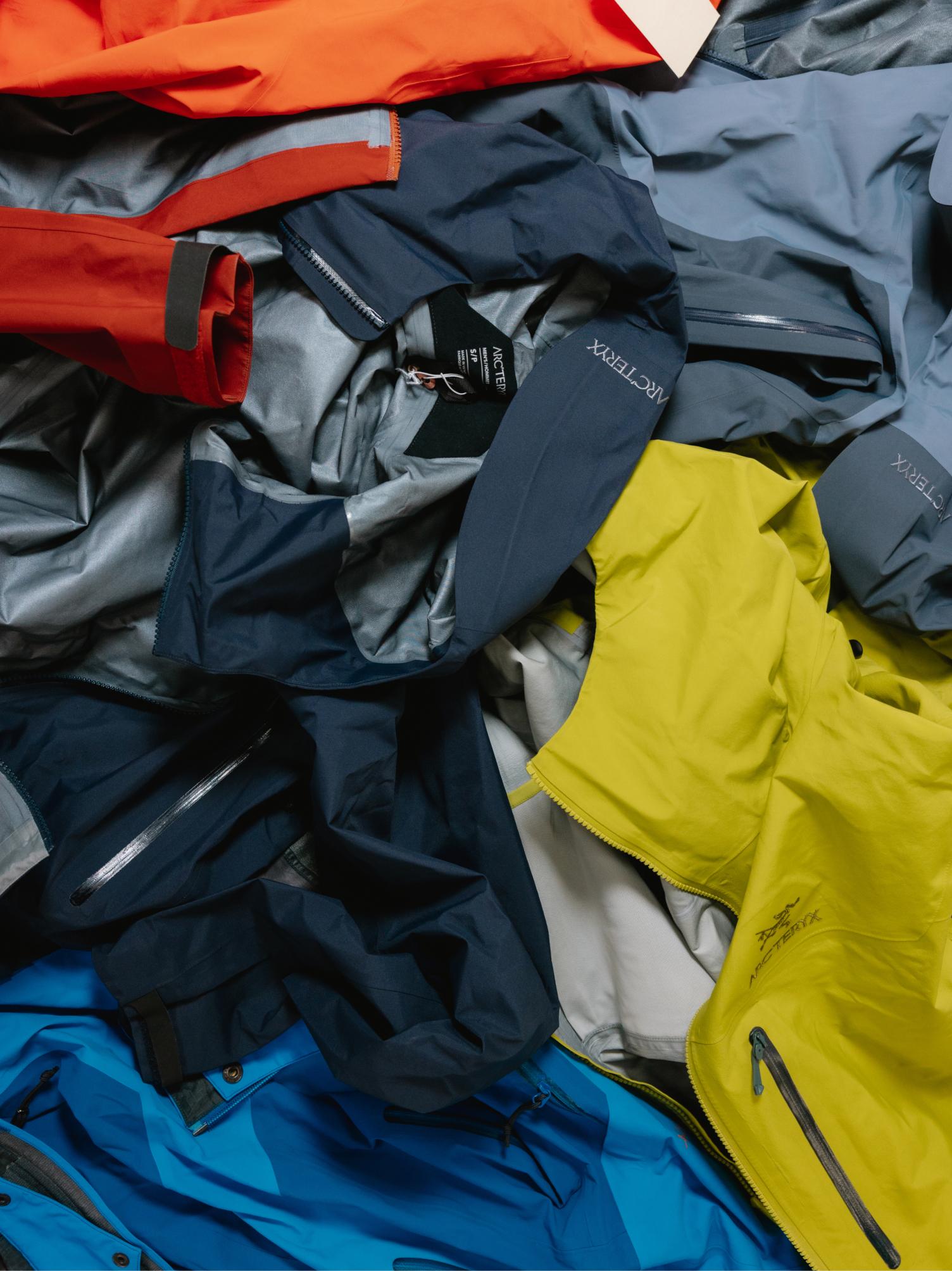 A pile of colorful Arc'teryx outdoor jackets.