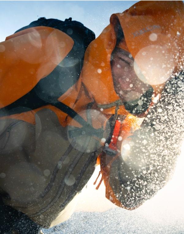 a person wearing an orange jacket with the word columbia on it
