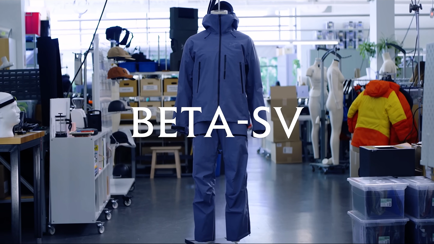 A blue outdoor suit on a mannequin in a workshop, with the text BETA-SV overlaid.