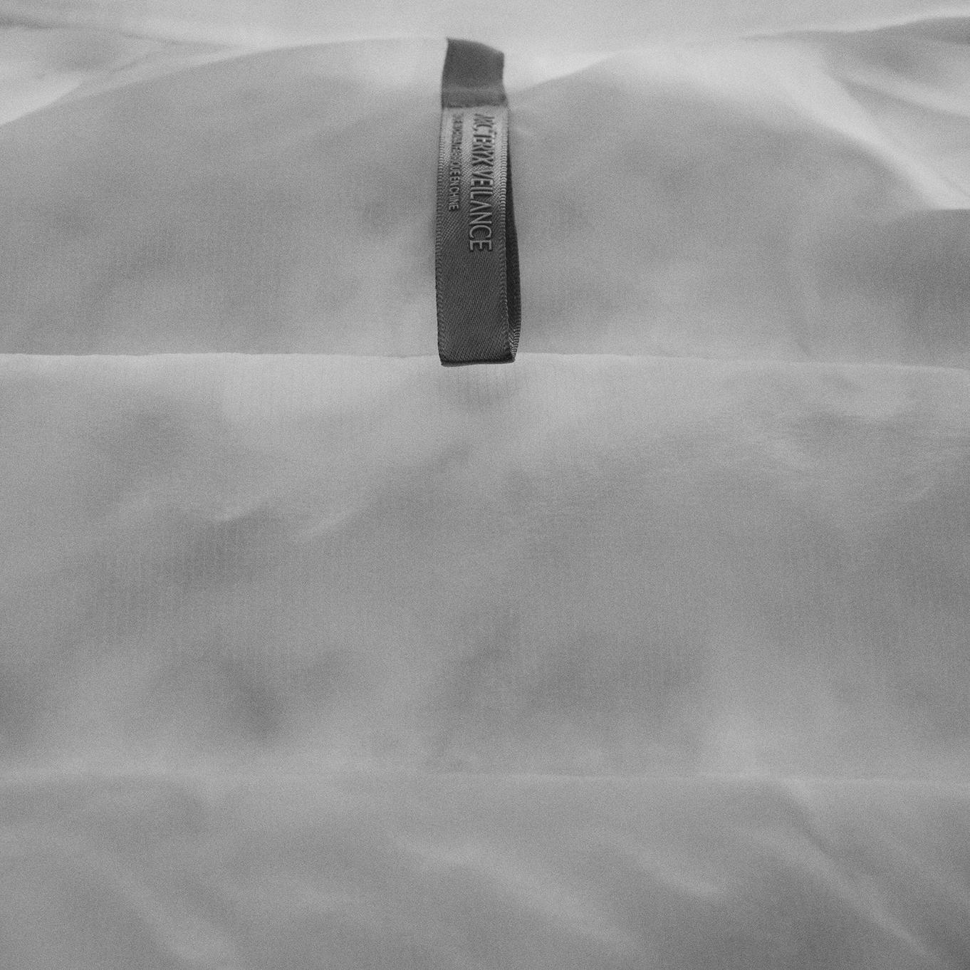 a black and white photo of a label on a white cloth