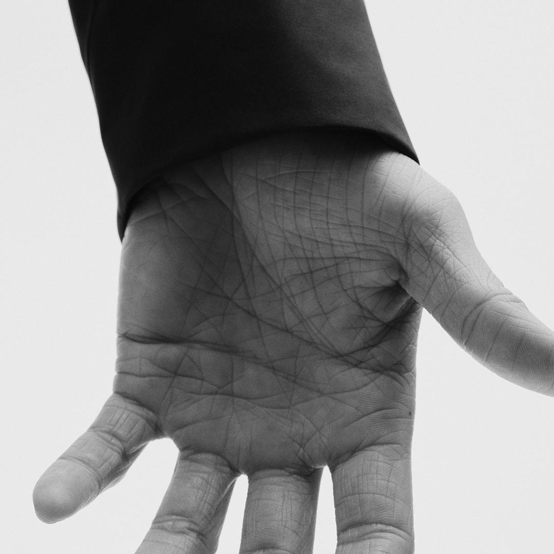 Open palm in black and white with a dark sleeve.