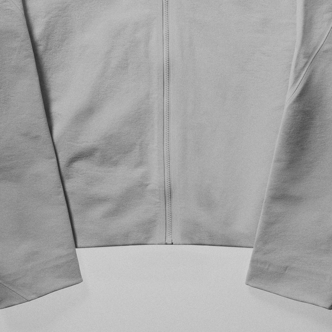 Light gray zippered garment with sleeves and bottom hem.