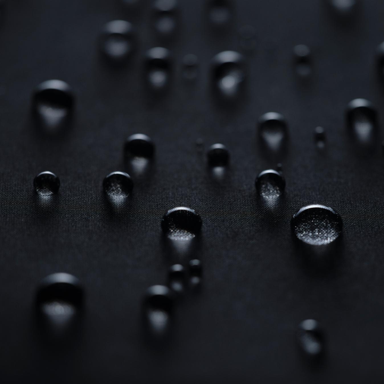 Water droplets on a dark hydrophobic surface.