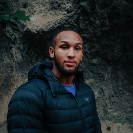 a man is smiling while climbing a rock wall