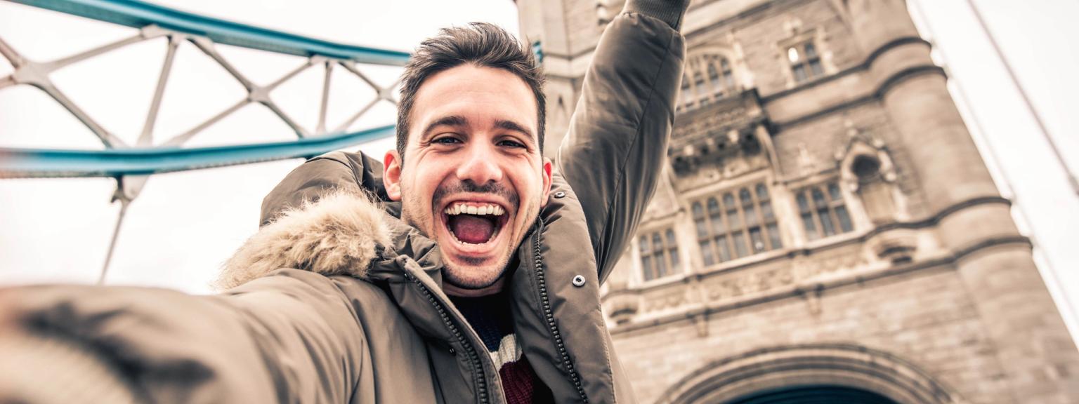 en man tar en selfie framför tower bridge i london