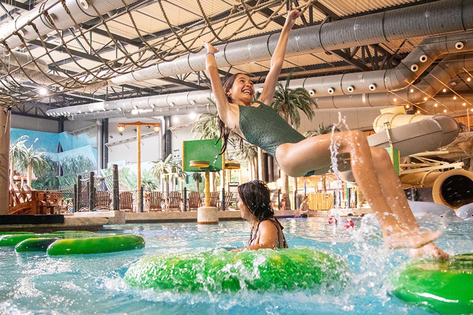 en flicka lyfts i luften medan hon åker rör i en vattenpark