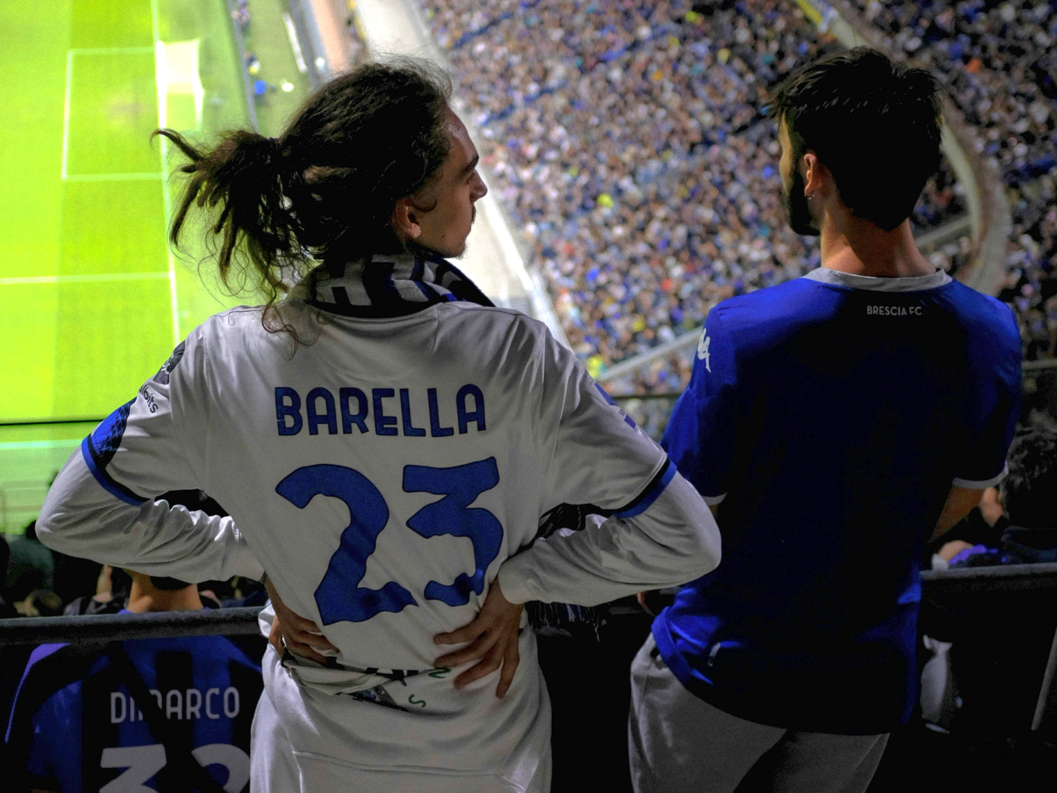 Viisi hymyilevää ystävää poseeraa Inter Milan -paidoissa ja huiveissa.