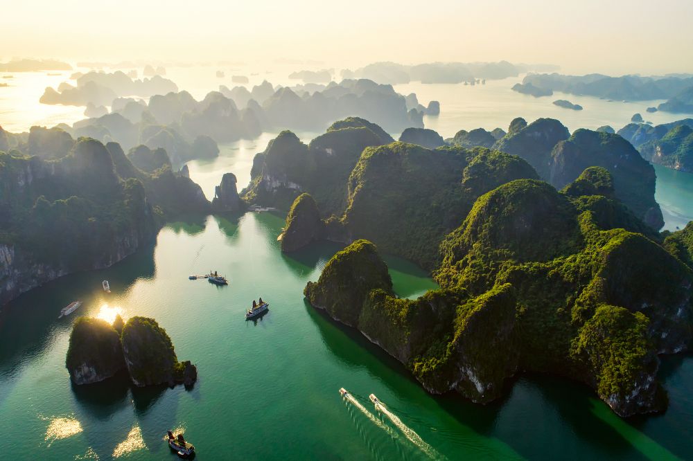 Ha Long Bay at sunrise with numerous forested islands and boats. Ha Long Bay, Vietnam
