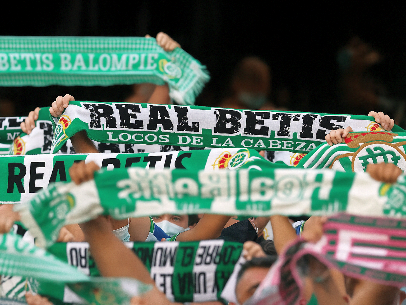 Voetbalfans houden groene en witte Real Betis-sjaals omhoog.