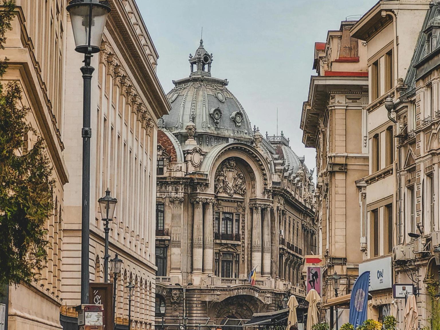 en gruppe mennesker går ned en brosteinsgate foran en stor bygning