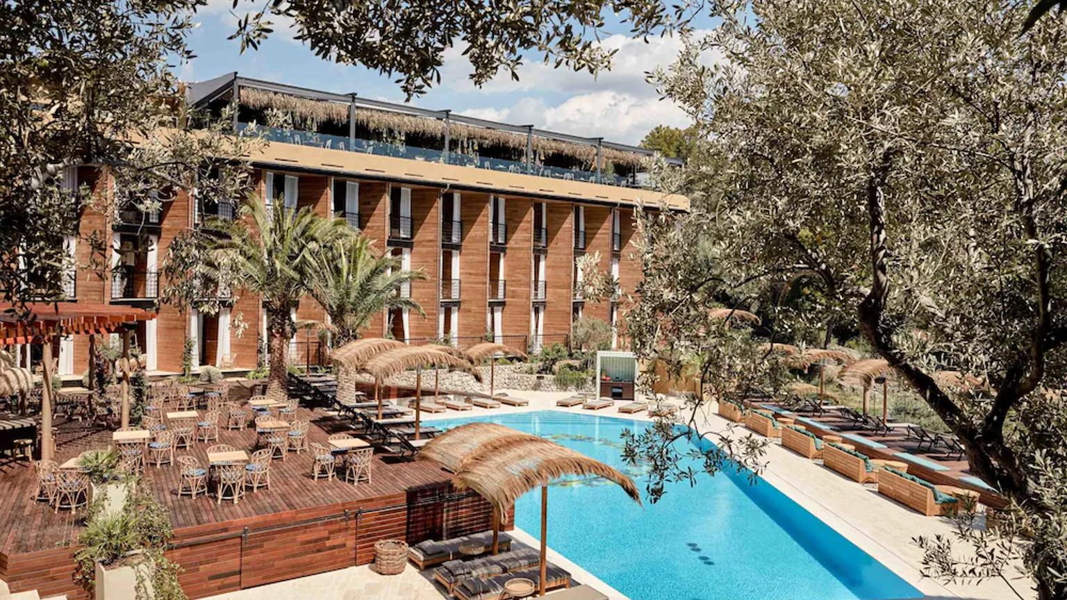 Ett modernt hotell med träfasader, en utomhusmatsal, en stor swimmingpool och solstolar med halmparasoller, omgiven av träd. Bikini Island & Mountain Hotel Port de Sóller - Endast för vuxna