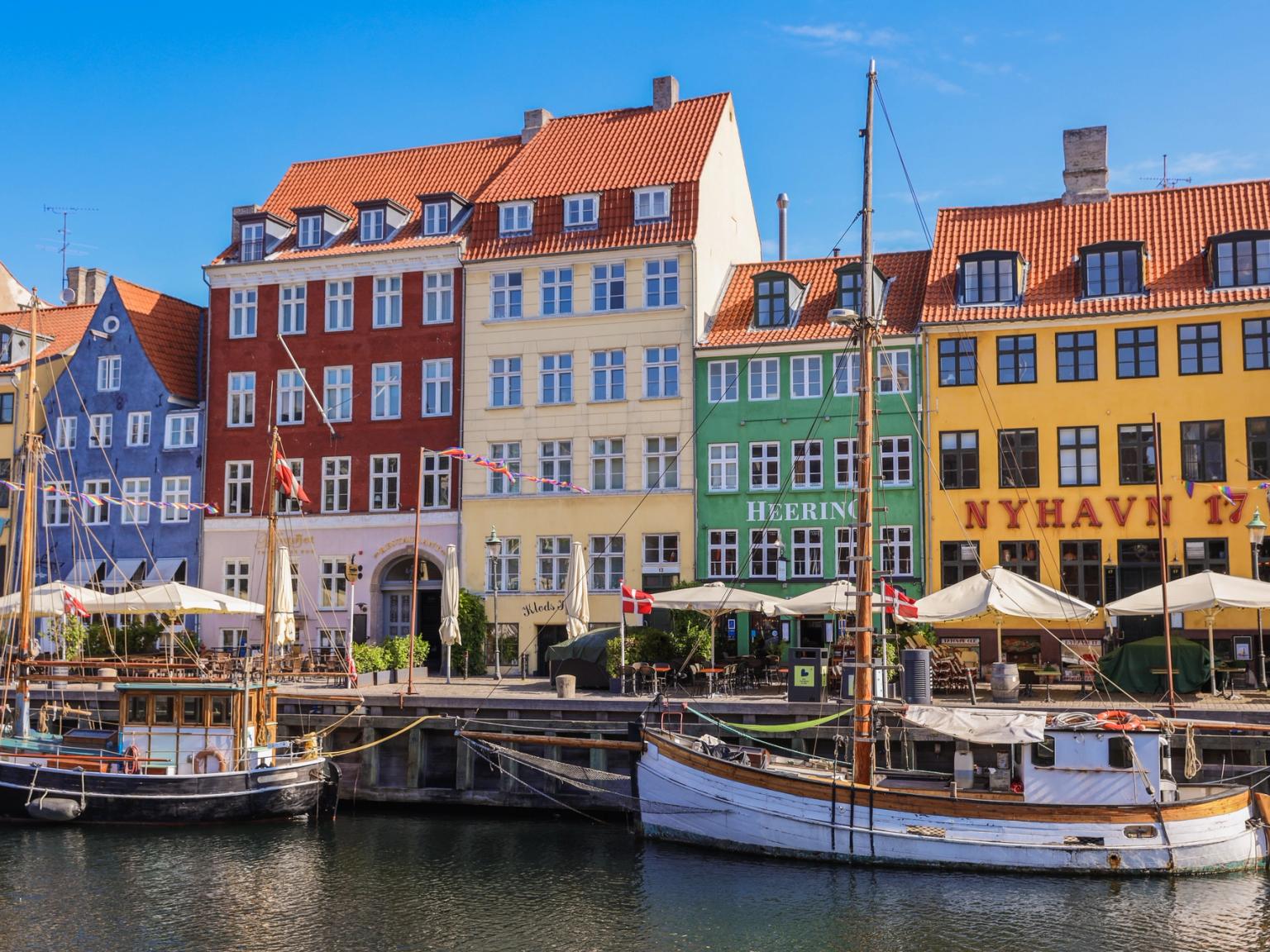 en båt är dockad framför en rad färgglada byggnader