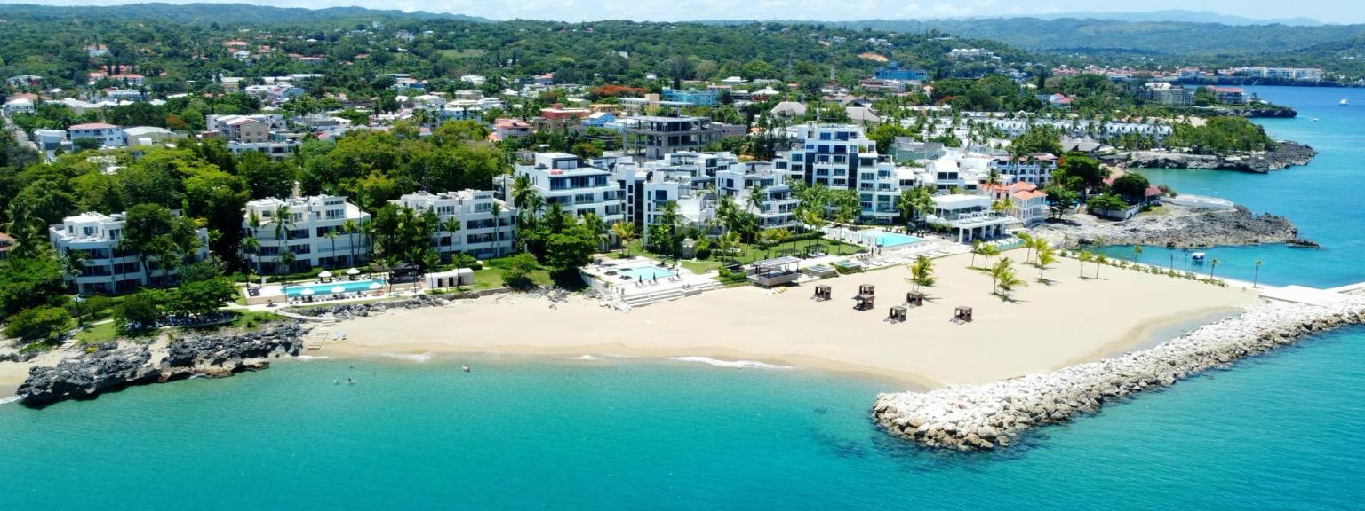 en flygvy över en strand med många byggnader och paraplyer