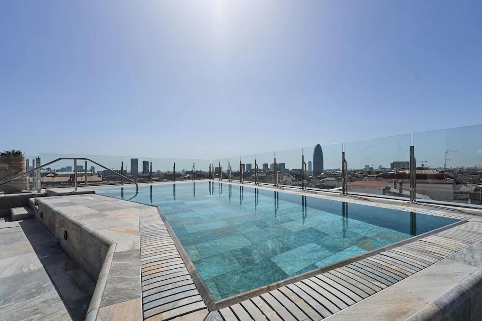 en stor swimmingpool på toppen av en byggnad med utsikt över staden.