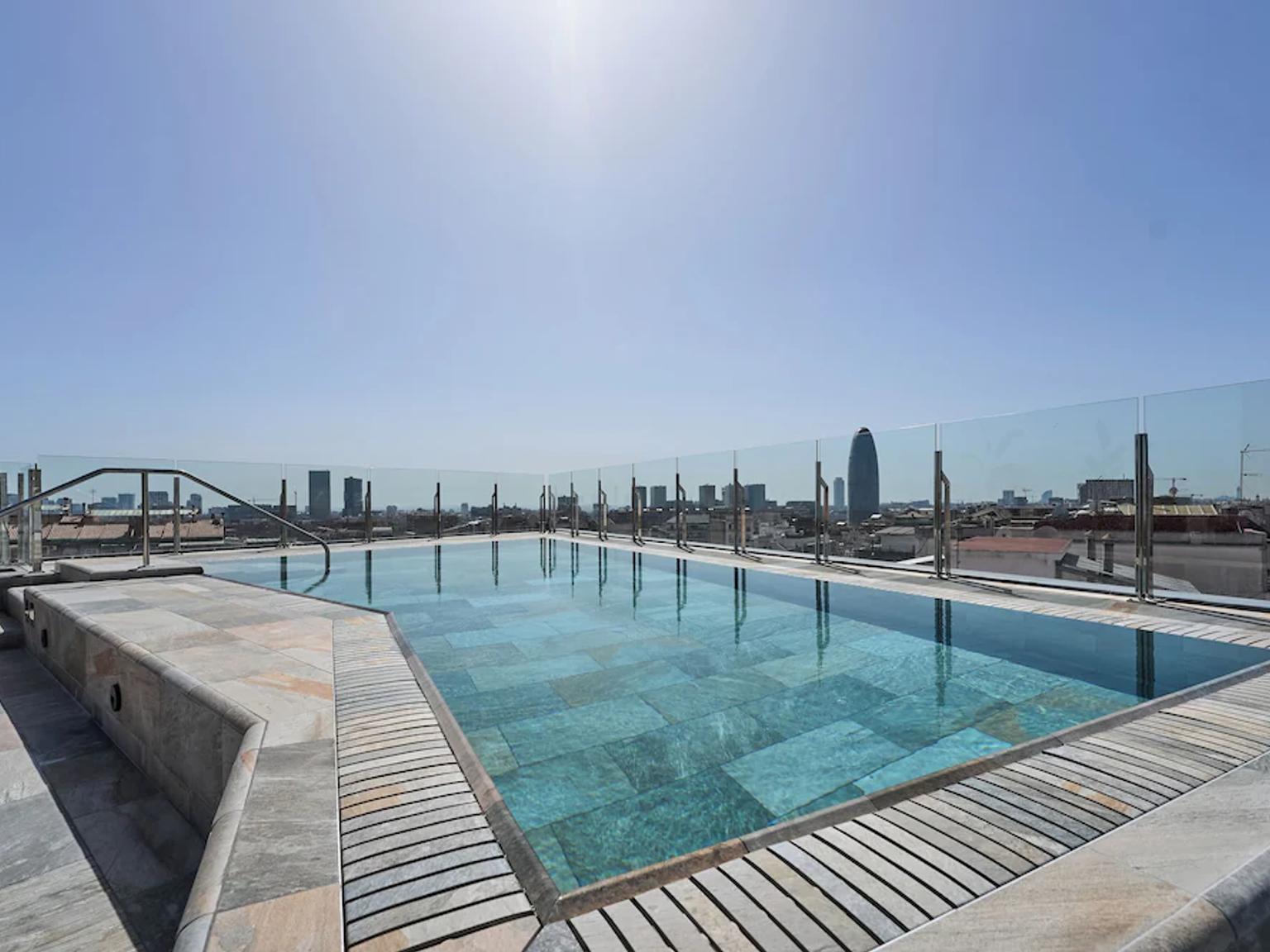 et stort svømmebasseng på toppen av en bygning med utsikt over byen.