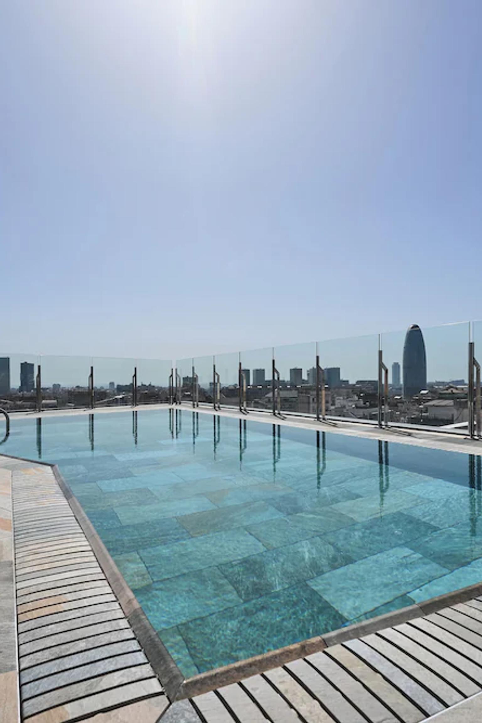 en stor swimmingpool på toppen av en byggnad med utsikt över staden.