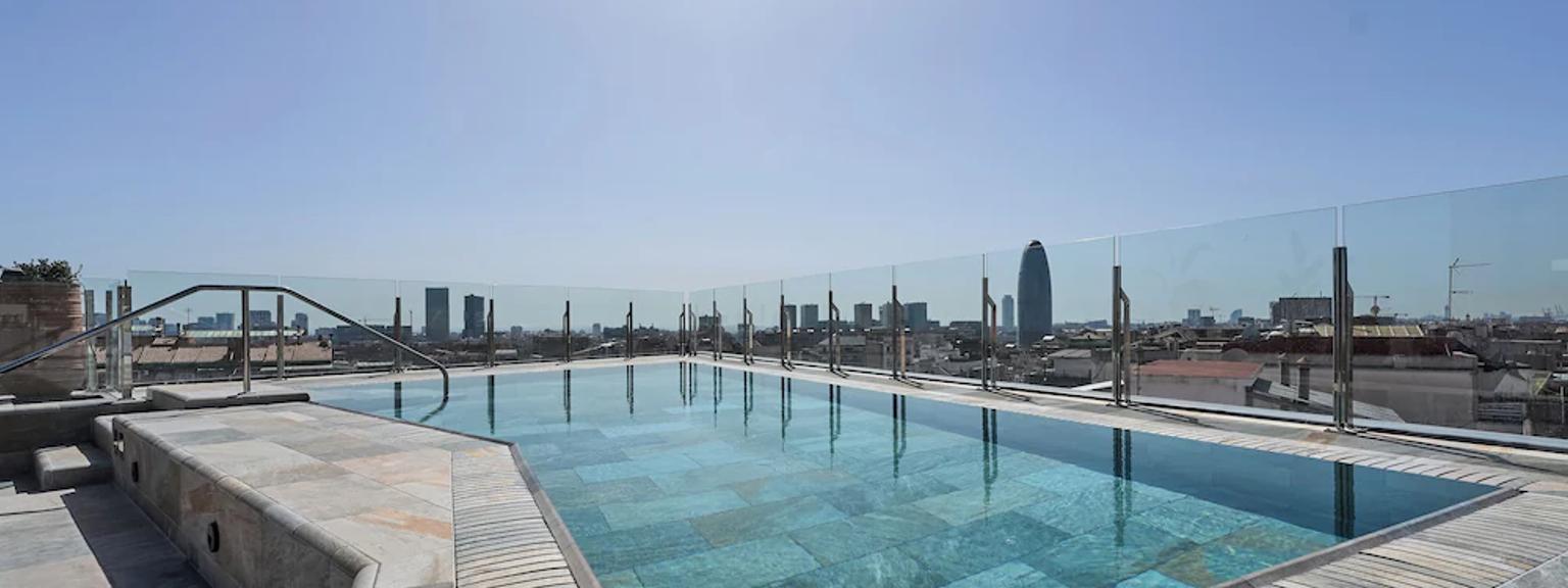 et stort svømmebasseng på toppen av en bygning med utsikt over byen.
