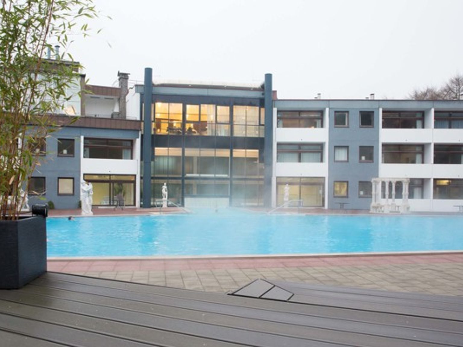 en stor byggnad med en simbassäng framför den