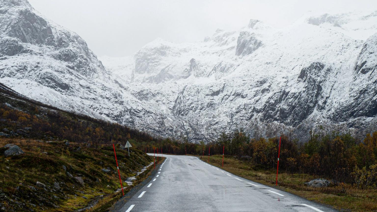 une route dans les montagnes avec de la neige sur les montagnes