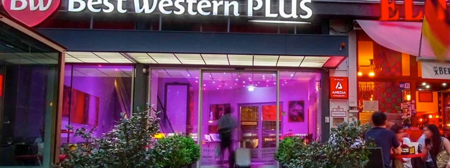 en grupp människor sitter utanför ett best western plus hotell