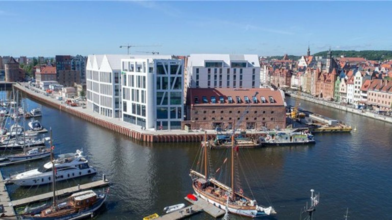 en luftvisning af en havn med både dockede og en stor bygning i baggrunden