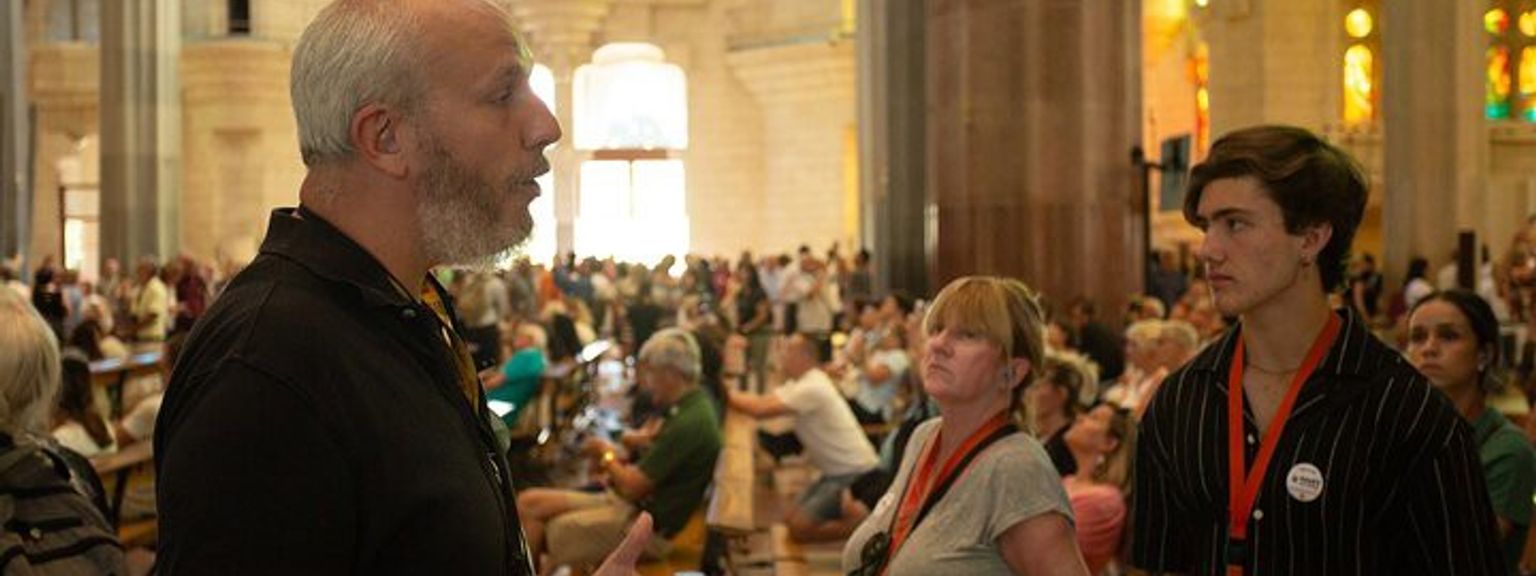 en mann snakker til en gruppe mennesker i en kirke