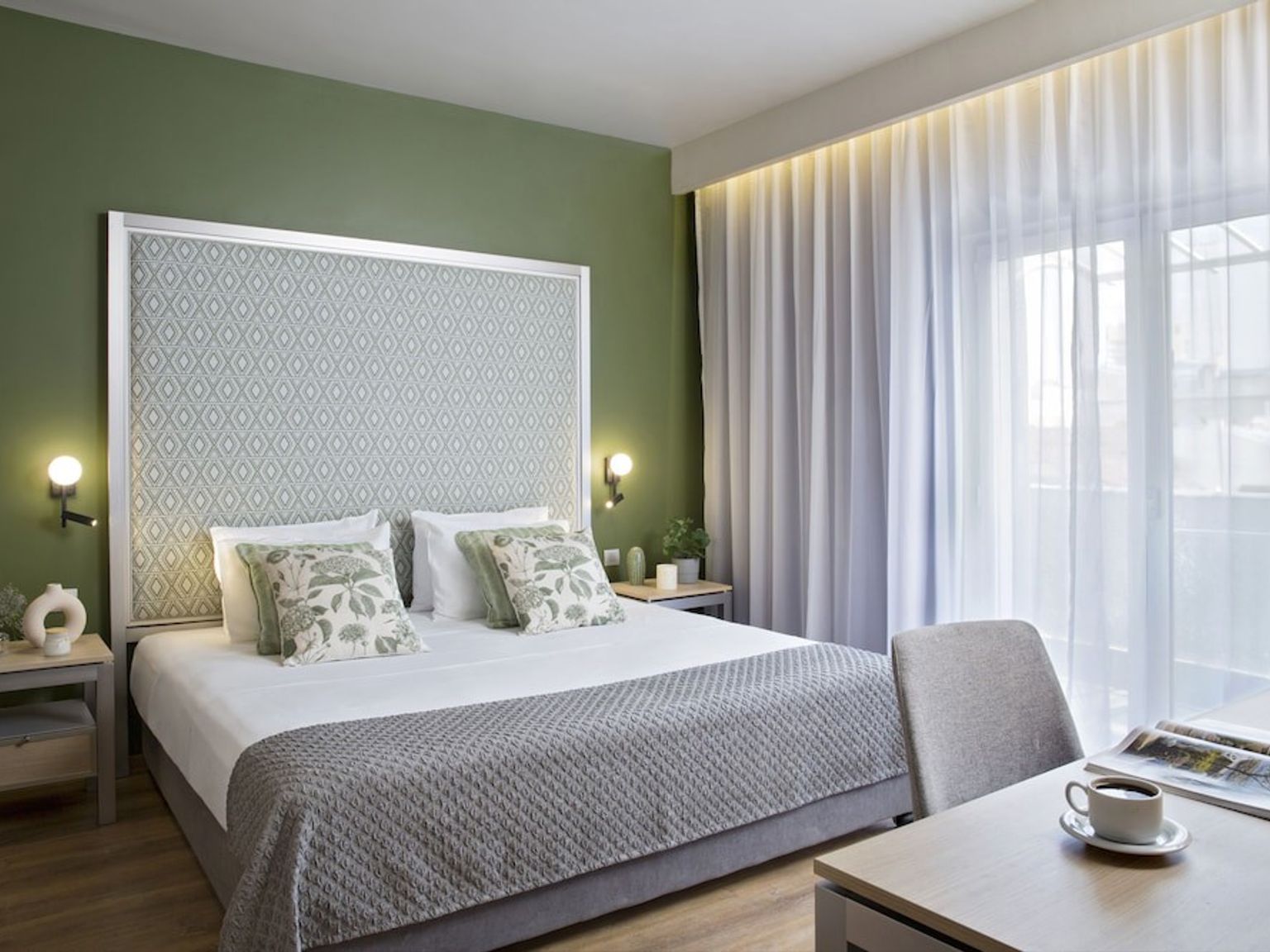 et hotellrom med en king size seng, skrivebord og stol