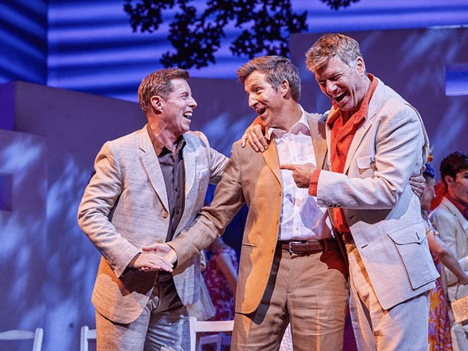 three men in suits are standing next to each other on a stage