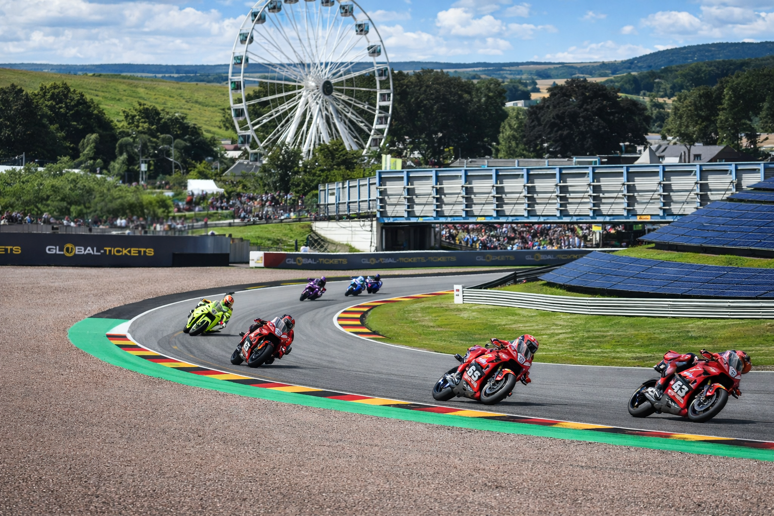 Motorcycles race on a track with German flag curbs, a Ferris wheel, and spectators.