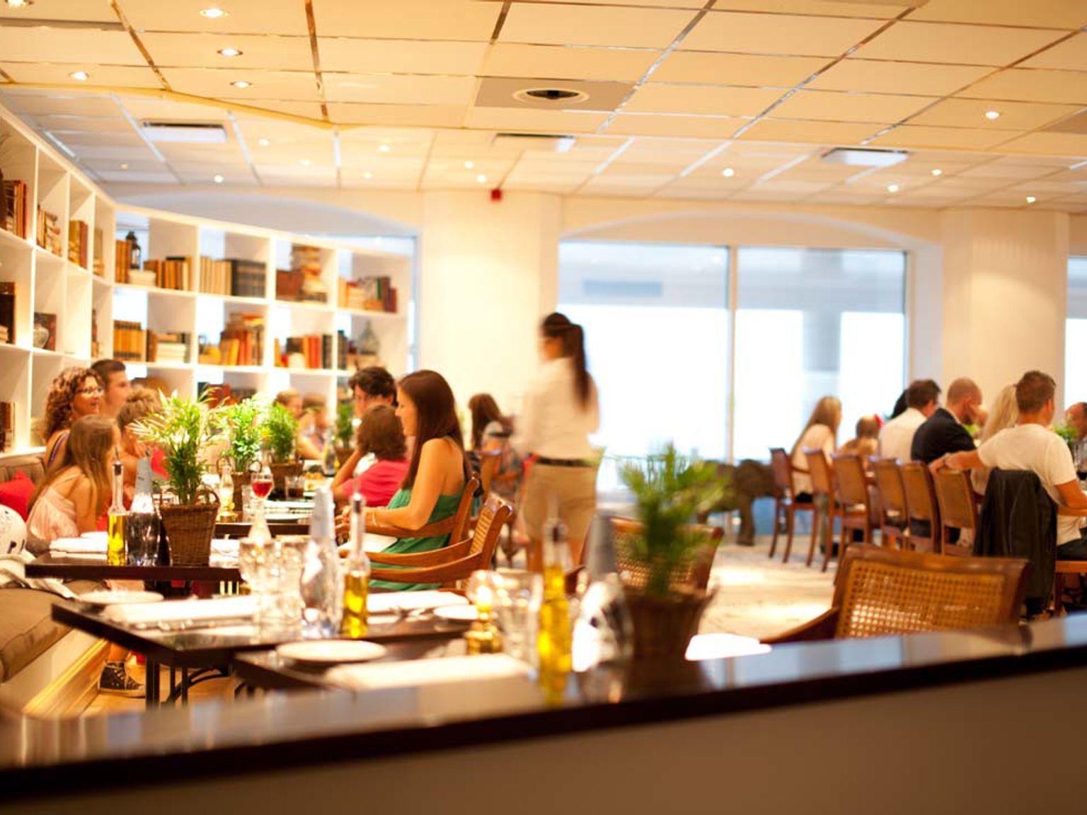 en grupp människor sitter vid bord på en restaurang