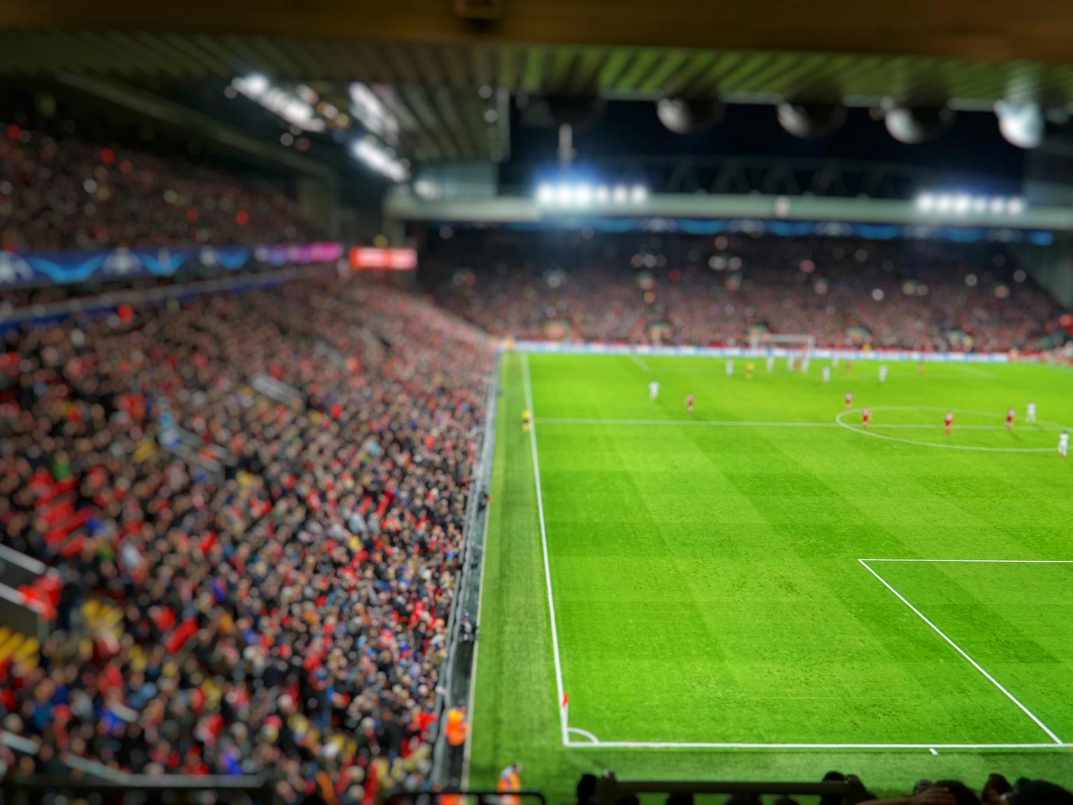 ein unscharfes Bild eines Fußballstadions mit einer Menge, die ein Spiel ansieht
