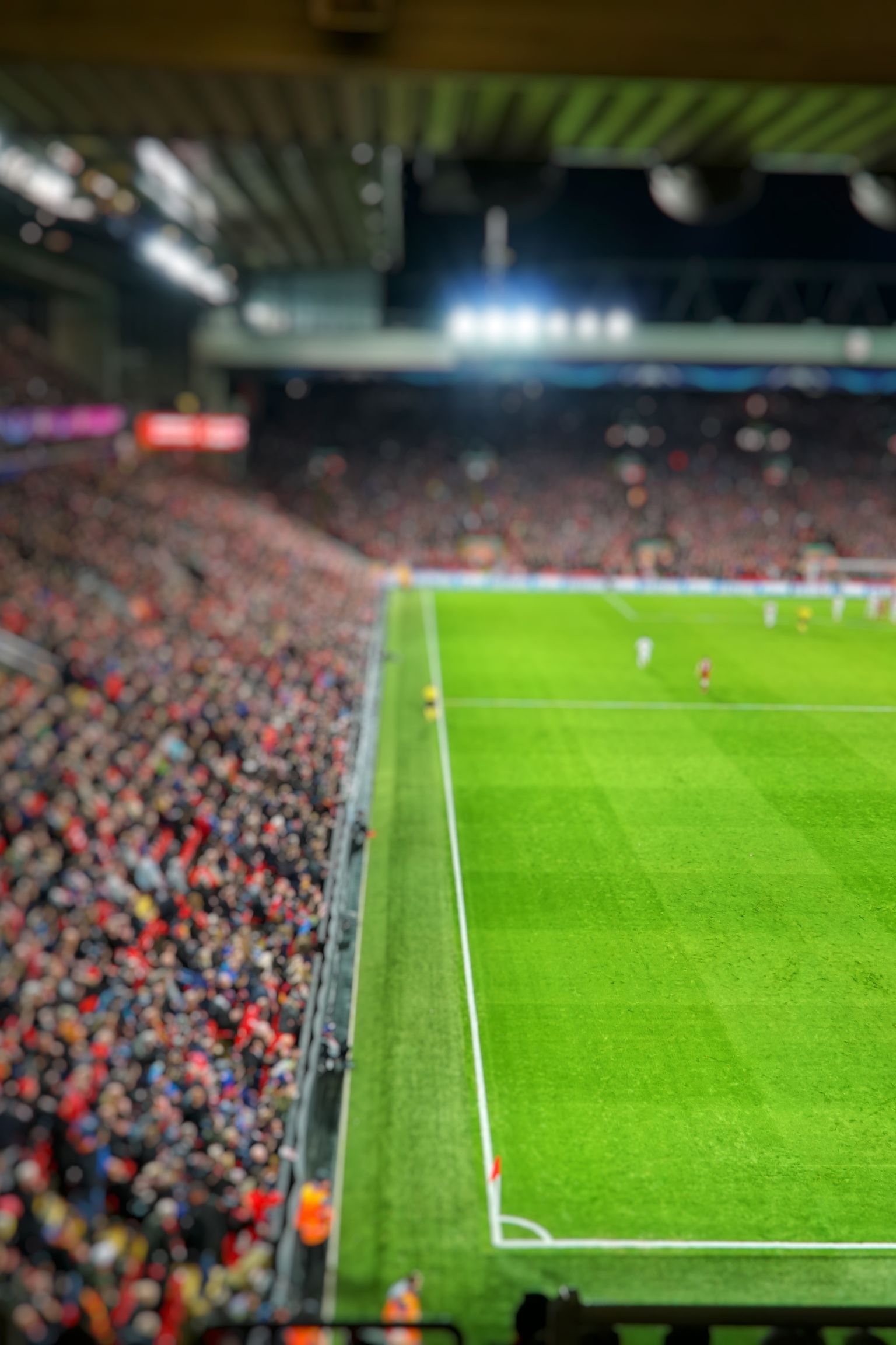 ein unscharfes Bild eines Fußballstadions mit einer Menge, die ein Spiel ansieht
