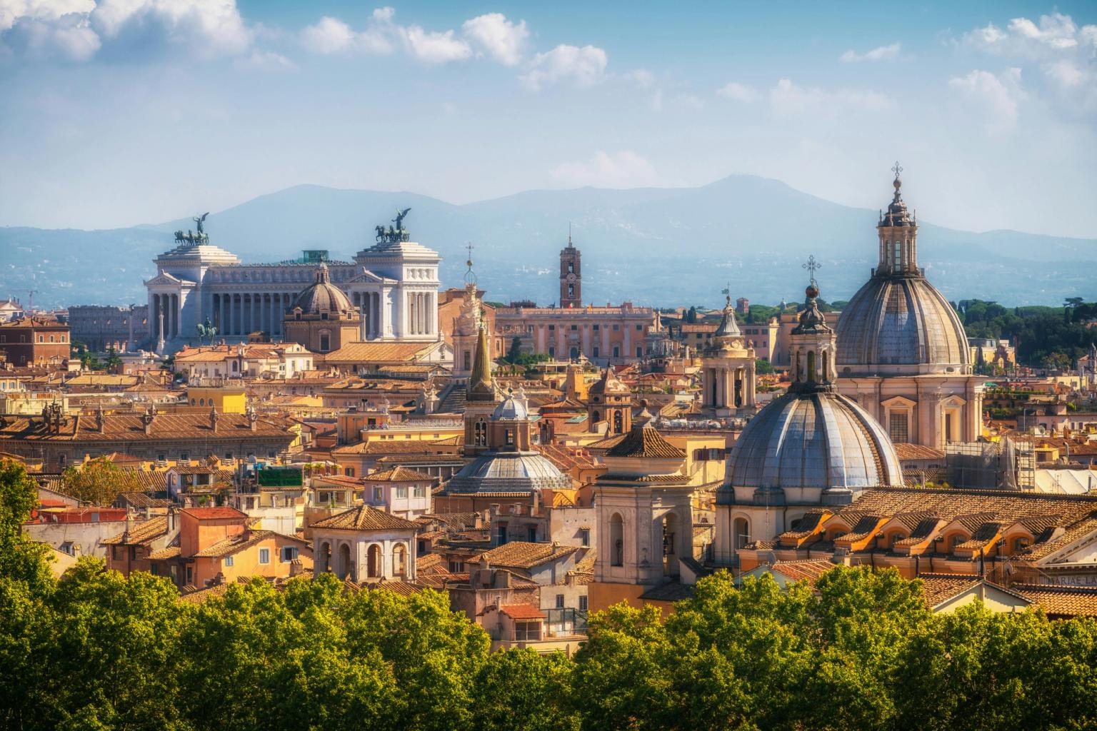 Panoramautsikt över Rom med historiska kupoler, Victor Emmanuel II-monumentet och bergen i fjärran. Rom, Italien