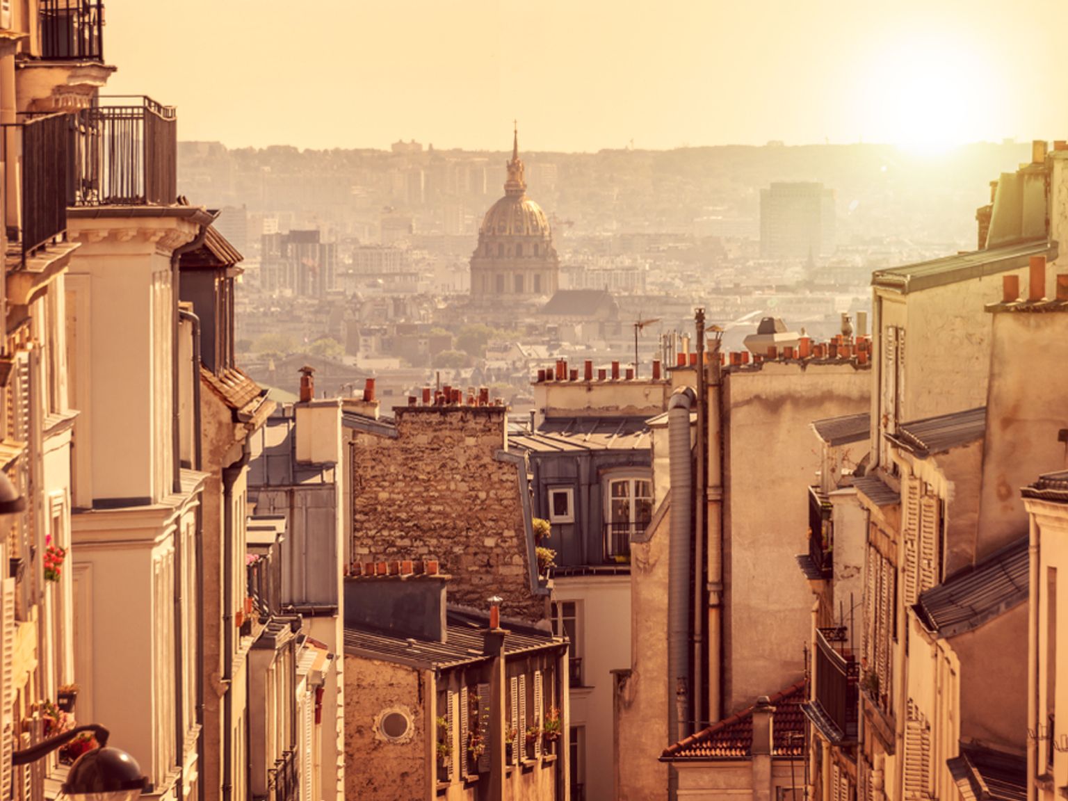 en smal gate i Paris med utsikt over byen ved solnedgang.