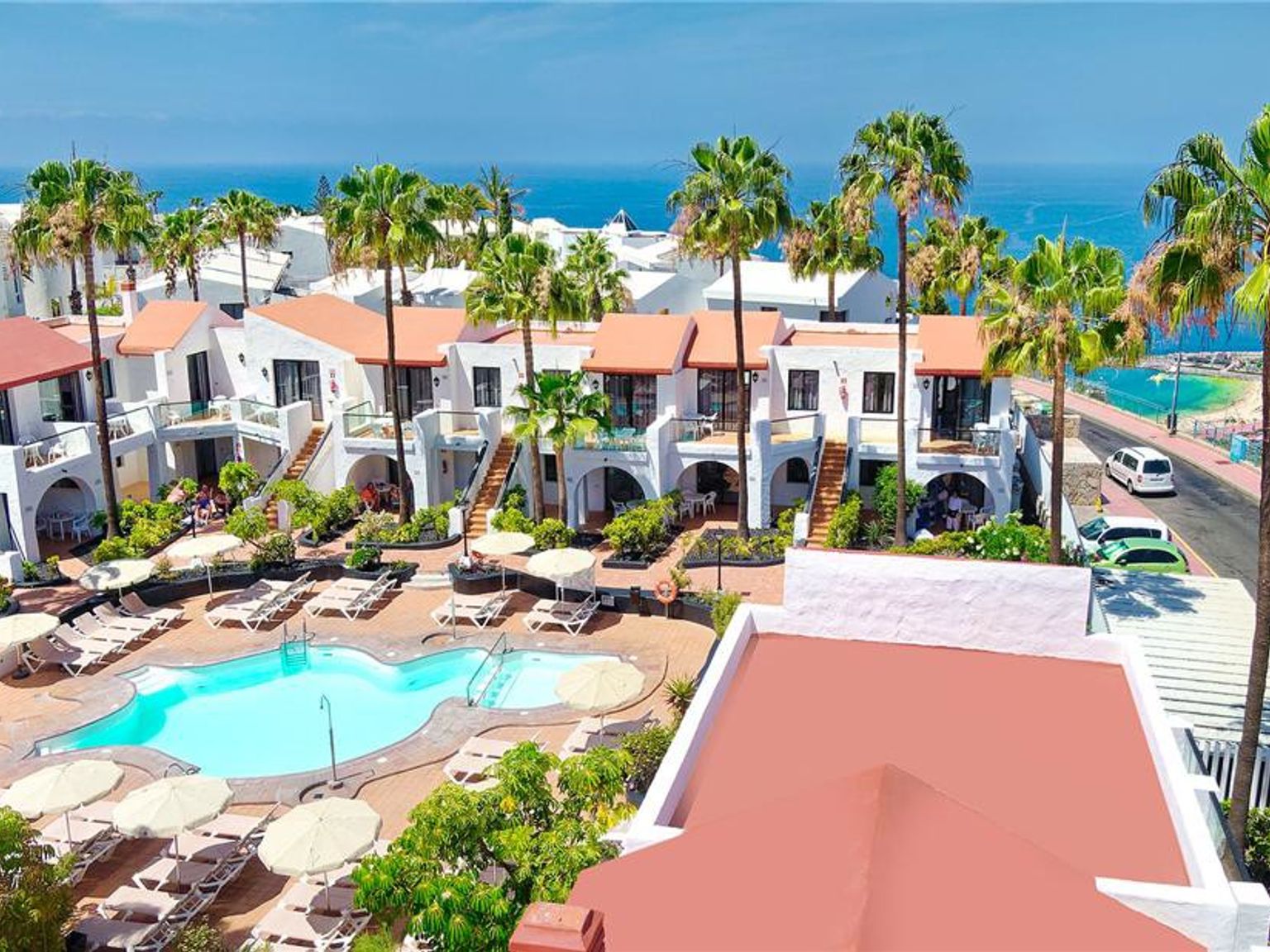 en luftig utsikt over et hotell med et svømmebasseng og palmetrær